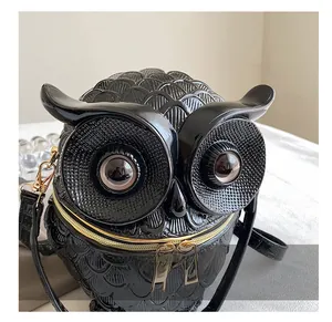 Detail der Eulen-Handtasche mit Reliefstruktur, goldenem Reißverschluss und schwarzem Finish