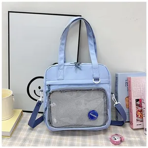 Detail view of the light blue canvas tote bag featuring a clear mesh front pocket