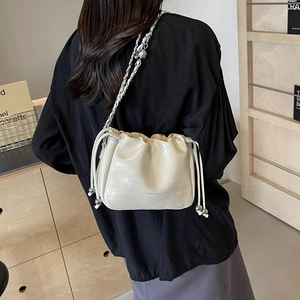 Chic beige crocodile pattern bucket bag with silver chain strap and drawstring closure
