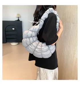 Détail du sac croissant gris montrant la texture plissée douce et la bandoulière