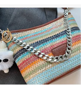 Detail of colorful striped straw bag with silver chain and white plush monster charm