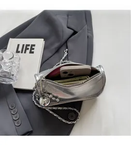 Vue intérieure montrant la capacité du sac en cuir argenté avec téléphone et chaîne
