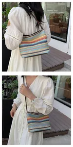 Close-up of rainbow striped straw shoulder bag with brown leather strap detail
