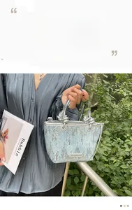 Detail of light blue sequin bucket bag featuring a knotted silver mirror handle