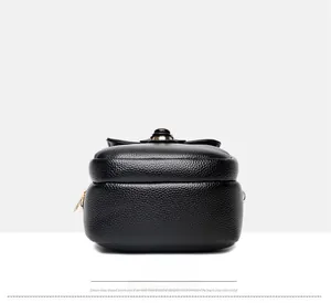 Dettaglio borsa in pelle grana nera con fiocco e decorazione a bottone in metallo