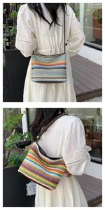 Detail of colorful rainbow striped straw shoulder bag with brown strap and woven texture