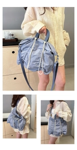 Detail of blue pleated fabric bag showing texture with dual cream drawstring accents