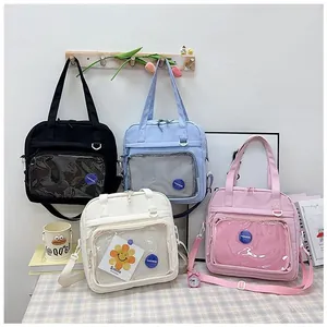 Detailed view of the transparent PVC pocket and circular FASHION logo on a nylon tote bag