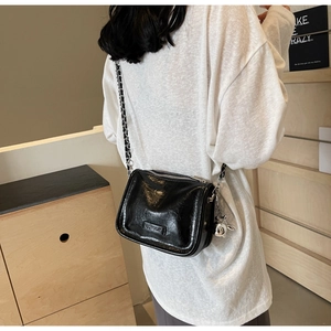 Détail du sac en similicuir noir avec chaîne argentée et breloque lapin mignonne