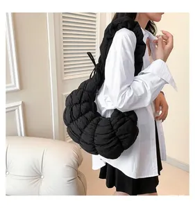 Détail d'un sac demi-lune noir matelassé en nylon doux pour la mode féminine chic