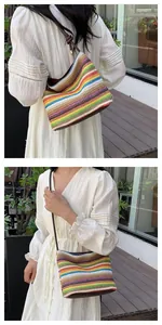 Detail of colorful striped straw shoulder bag with brown leather strap in an outdoor setting