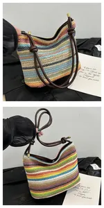 Detail of colorful rainbow straw tote bag with brown tube handles and gold hardware accents