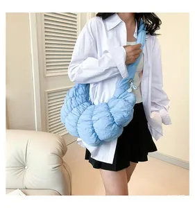 Vue latérale du sac croissant bleu clair matelassé avec bandoulière plissée