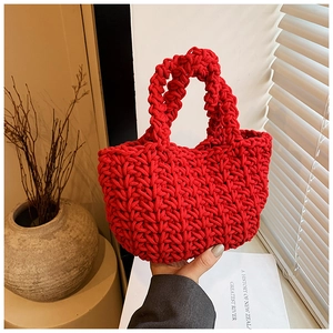 Dettaglio borsa a secchiello rossa tessuta a mano con trama a maglia grossa e design a U