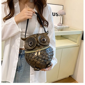 Detailaufnahme der Eulen-Handtasche mit bronzener Federstruktur und Metallreißverschluss