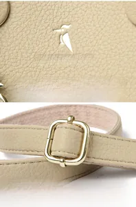 Detail of lychee pattern cream leather tote bag with gold buckle and brand logo