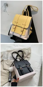 Close-up of contrast PU leather backpack with vintage buckles and plush charm accessory