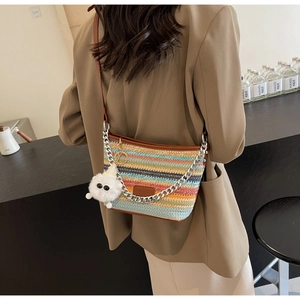 Detail of colorful striped woven bucket bag with metal chain and leather shoulder strap
