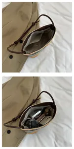 Internal view of colorful straw woven bag showing spacious storage and leather strap detail