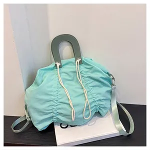 Detail of mint green drawstring canvas bag with soft pleated fabric and sage leather strap