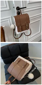 Detail of color-block PU leather backpack with vintage metal buckles and plush pendant