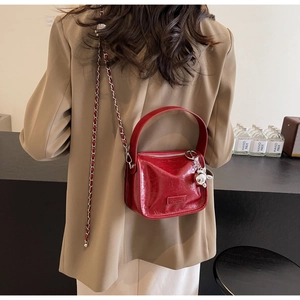 Détail du mini sac boîte rouge brillant avec chaîne en métal et charm lapin argenté