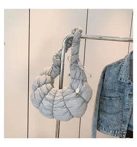 Gros plan détaillé du sac croissant matelassé gris-bleu avec plis sur un cintre