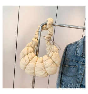 Détail du sac croissant crème avec plis texturés et matériau en nylon léger et souple