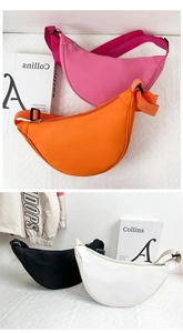 Détail de sacs bandoulière croissants en nylon coloré avec larges sangles et zips métalliques