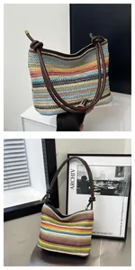 Detail of colorful woven straw bag with knotted brown leather shoulder strap handle