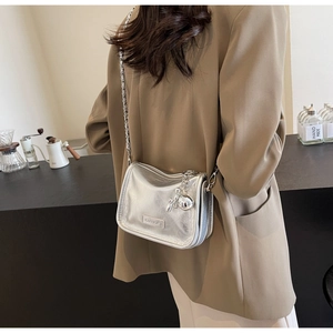 Détail du sac bandoulière argenté avec bandoulière chaîne et pendentif lapin mignon