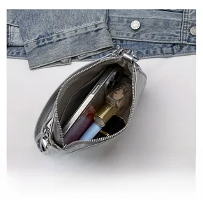Vue intérieure détaillée de la pochette argentée avec smartphone, parfum et rouge à lèvres