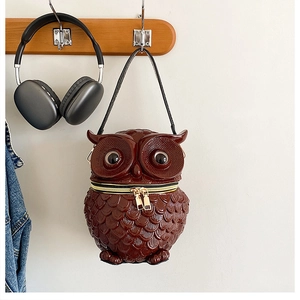 Nahaufnahme der Eulen-Handtasche aus Kunstharz mit Federtextur und doppelten Metallreißverschlüssen