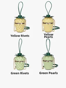Detail of strawberry shaped bags with rivet and pearl accents in green and yellow