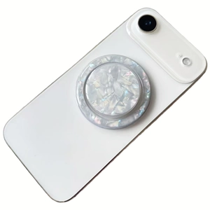 Macro shot of circular shell texture phone socket grip on a sleek white smartphone