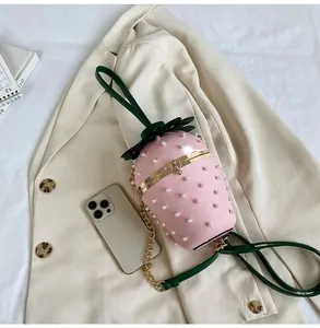 Detailed top view of a pink strawberry-shaped bucket bag with pearls and gold chain