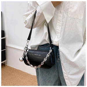 Détail d'un sac sous le bras en cuir noir avec chaîne argentée et logo mode