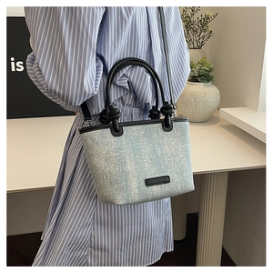 Light blue denim tote bag with knot handle detail and sequins shown in lifestyle setting