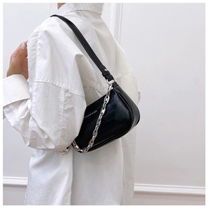 Détail du sac sous l'aisselle en cuir noir avec chaîne argentée et motif imprimé