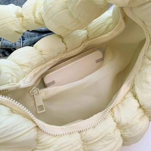 Intérieur spacieux d'un sac croissant beige avec une poche intérieure zippée
