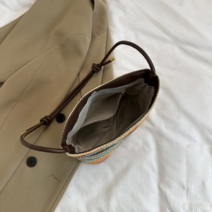 Rainbow striped straw bucket shoulder bag with brown leather straps and woven texture