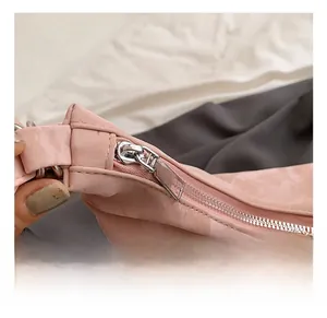 Close-up of shiny silver zipper and buckle on pink pleated texture tote bag detail