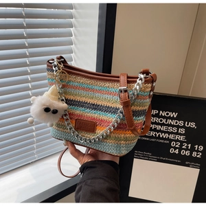 Close-up of colorful striped straw bucket bag with leather trim and sheep charm