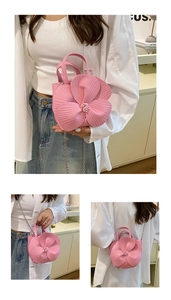 Detail view of pink petal bucket bag showing 3D camellia texture and bead stamens