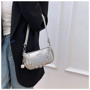 Détail du sac baguette argenté effet crocodile avec chaîne en métal et logo mode