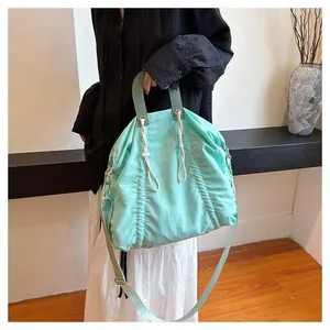 Detail of mint green drawstring canvas bag with leather handles and pleated texture fabric