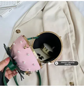 Interior capacity of strawberry bucket bag showing phone and compact powder inside