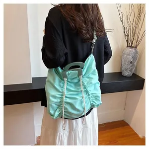 Detail of mint green pleated canvas bag featuring unique semi-circular handle and drawstring