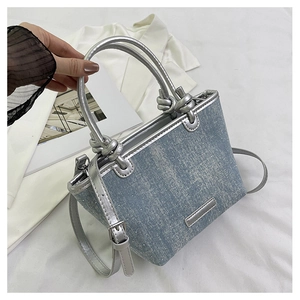 Detailed macro view of light blue denim tote with shimmering rhinestones and silver metallic trim