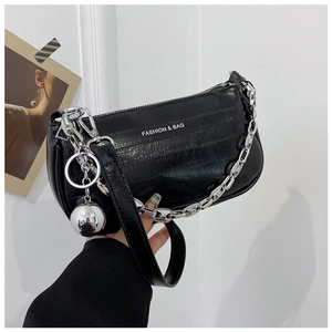 Gros plan du sac en cuir plissé noir avec chaîne argentée et pendentif boule métal
